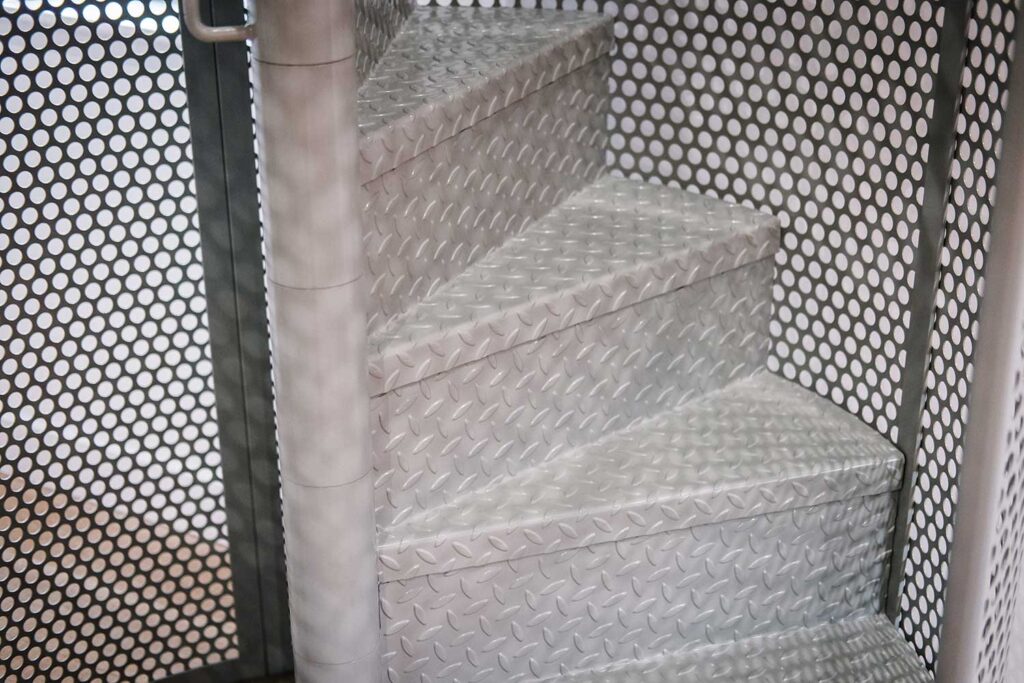 Bespoke metal spiral staircase enclosed in a spherical perforated steel design