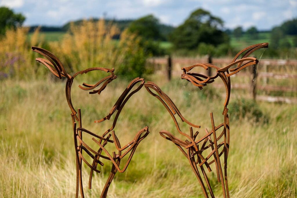 Boxing hares garden sculpture in grasses