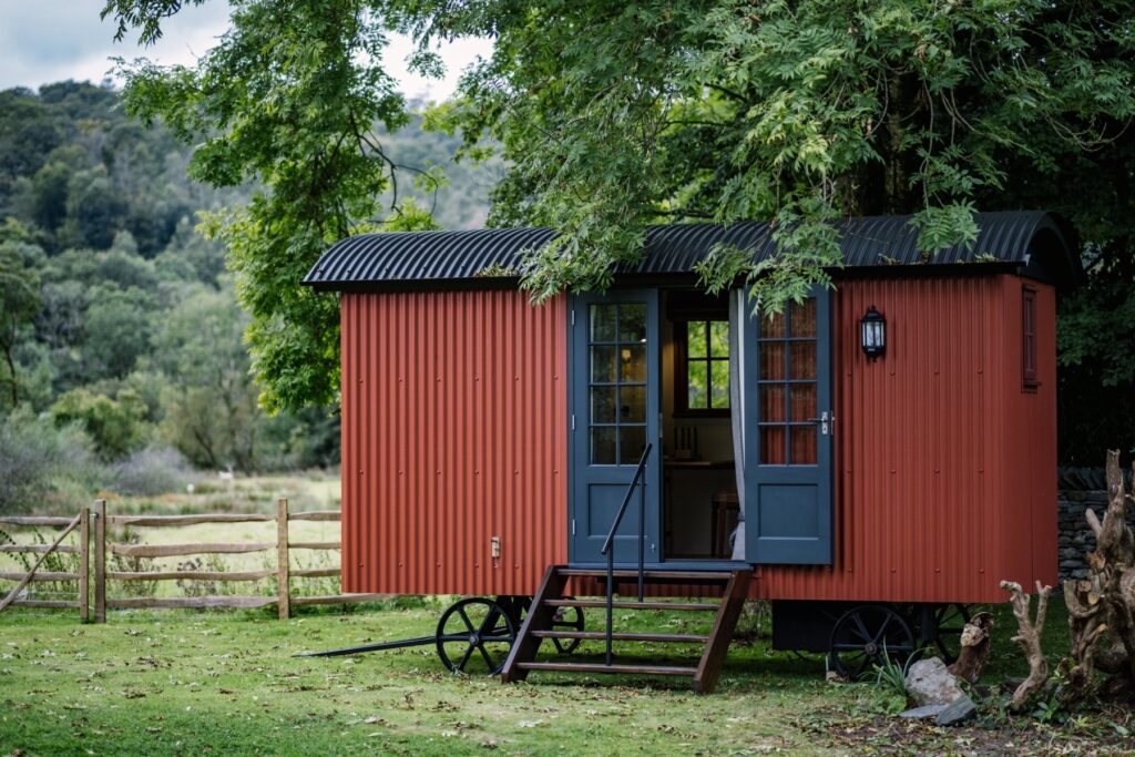 Bespoke shepherds hut nestled in the garden and surrounded by cleft fencing