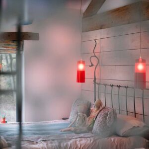 Obscured view of a child's bed, wall cladding and bedside lights