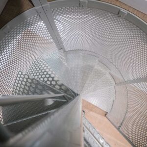 Bespoke metal spiral staircase enclosed in a spherical perforated steel design