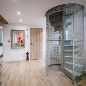 Bespoke metal spiral staircase enclosed in a spherical perforated steel design