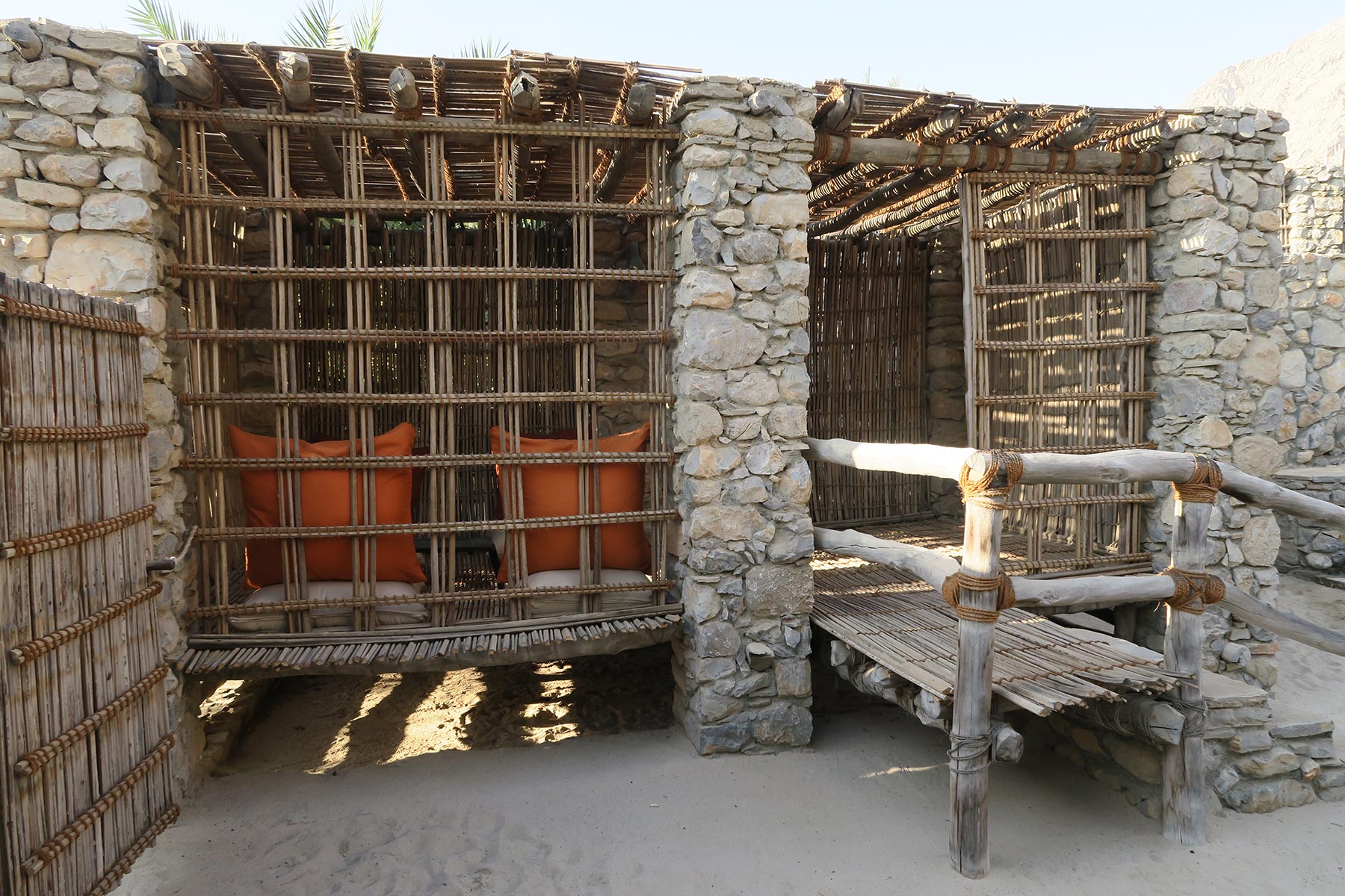 A biophilic designed outside seating space with natural stone walls and craftsman built wooden features