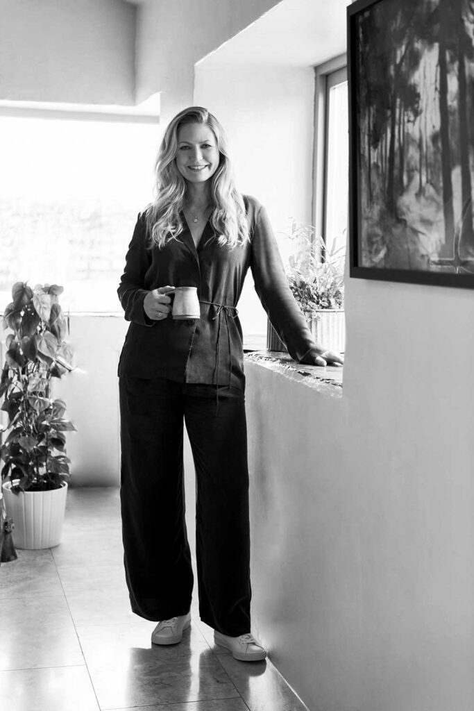 Charlotte Findlater, a luxury and high-end interior designer, standing up with a coffee mug