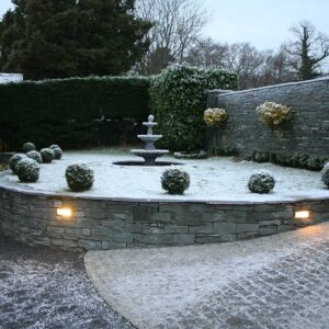 Front garden with curved stone walling with a light dusting of snow