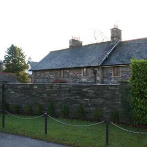 Large stone wall adding privacy to a house entrance