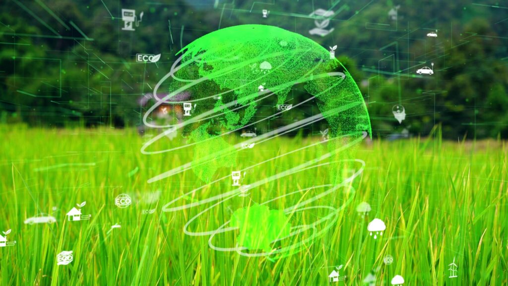 Computer generated image of the globe and sustainability related icons against a grassy field