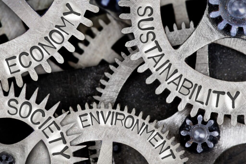 Economy, Society, Environment, Sustainability words engraved into a number of metal cogs