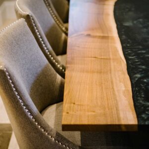 View of the left side of a bespoke dining table made from combining resin and wild walnut to create a river resin design