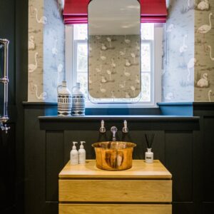 Copper wash basin with hanging vanity mirror in bathroom