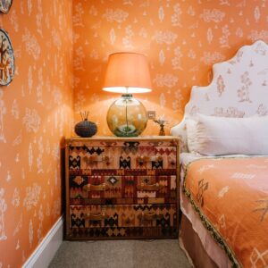 Bedroom with a Moroccan orange coloured theme, view of the bedside table and lamp