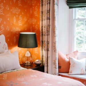 Bedroom with a Moroccan orange coloured theme, view of the window seat and bed side lamp