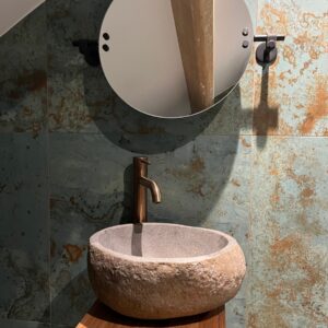 Small ensuite with a natural stone bowl, verdigris wall tiles and large wall mounted vanity mirror
