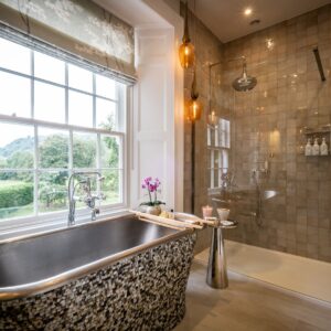 Master ensuite with a mother of pearl freestanding bath, large walk in shower and a view of outside