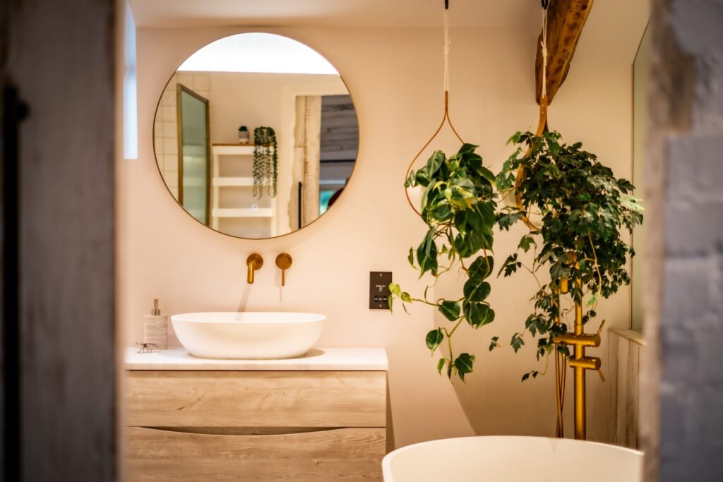 Biophilic designed ensuite bathroom with wood flooring, wall cladding in a calm Scandi style designed by Charlotte Findlater Design, an award winning interior design studio specialising in luxury, high-end residential & commercial projects that respect time, nature and people.
