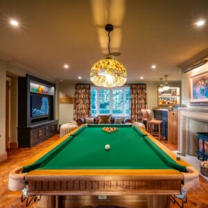 Luxury games room with bespoke Oak pool table, parquet flooring, stone fireplace, built ins and media wall