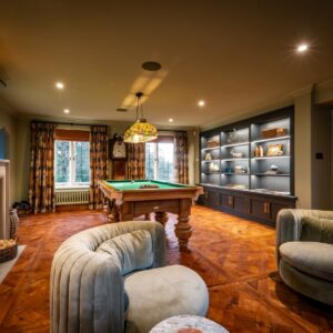 Luxury games room with bespoke Oak pool table, parquet flooring, swivel chairs and media wall