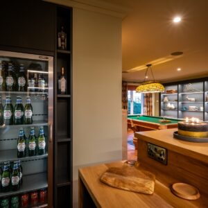 Luxury games room bar area with a full height beer fridge