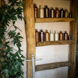A close up of a bespoke beam shelf with vintage ink bottles